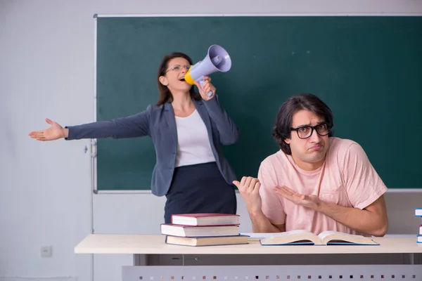 Old female teacher and male student in the classroom — Stock Photo, Image