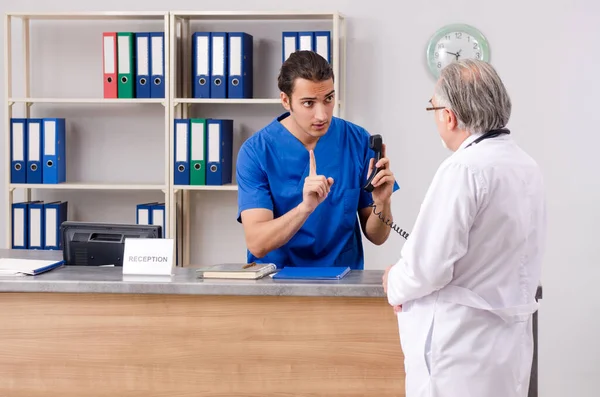 Hastanedeki resepsiyonda iki doktor konuşuyor. — Stok fotoğraf