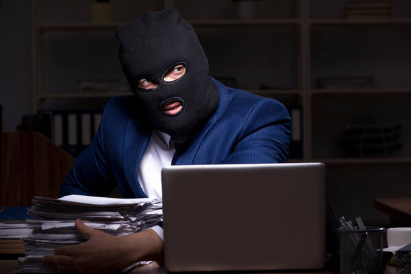 Male employee stealing information in the office night time