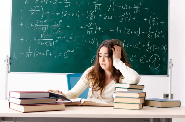 Młoda nauczycielka matematyki przed tablicą. — Zdjęcie stockowe