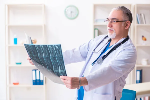 Klinikte çalışan yaşlı erkek doktor. — Stok fotoğraf