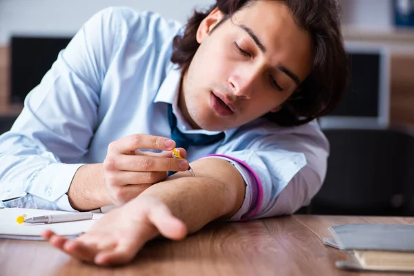 Joven con problemas con narcóticos en el lugar de trabajo — Foto de Stock