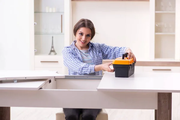 Giovane bella donna che assembla mobili a casa — Foto Stock