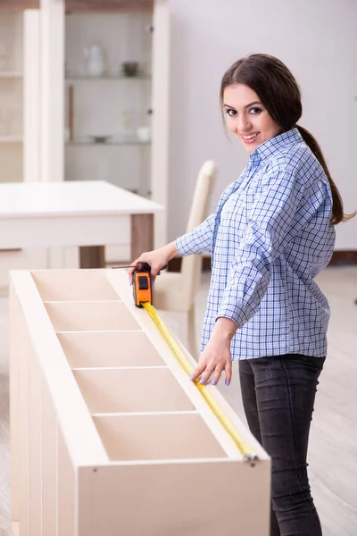 Ung vacker kvinna montera möbler hemma — Stockfoto