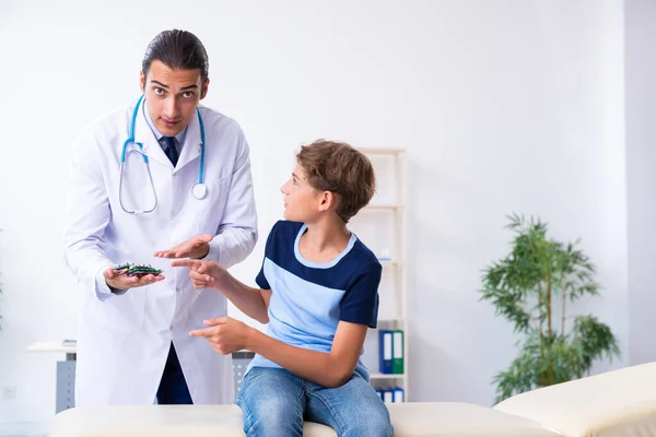 Young male doctor examining boy in the clinic — Stock Photo, Image