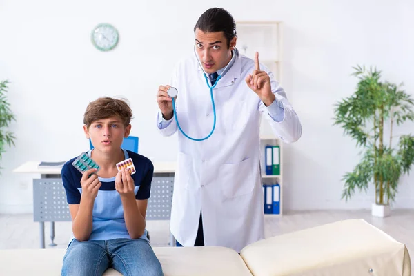 Joven médico examinando a un niño en la clínica —  Fotos de Stock