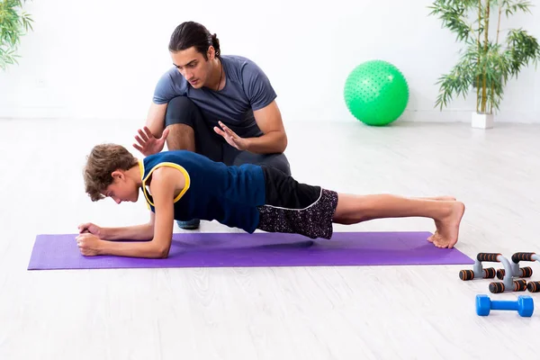 Jovem pai e seu filho fazendo exercícios — Fotografia de Stock