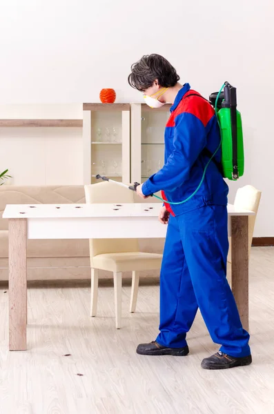 Jovem empreiteiro fazendo controle de pragas em casa — Fotografia de Stock