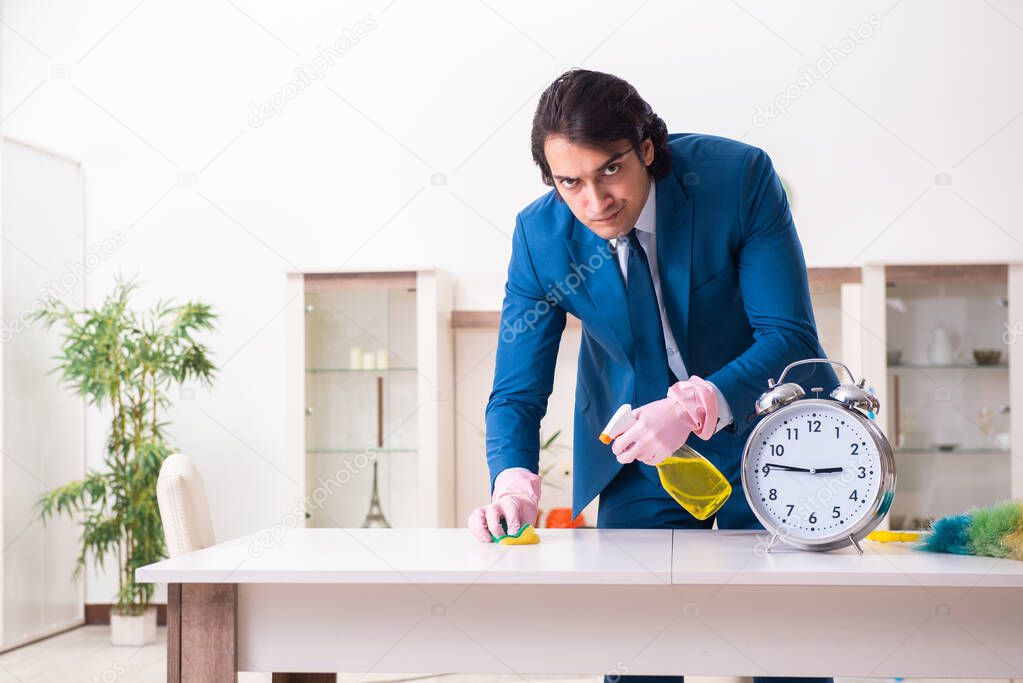 Young businessman cleaning the house