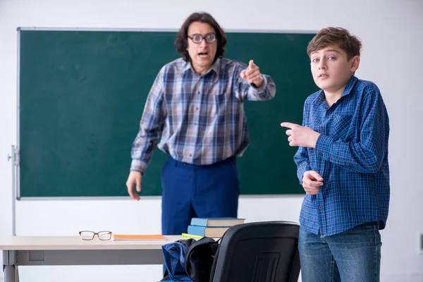 Funny male teacher and boy in the classroom