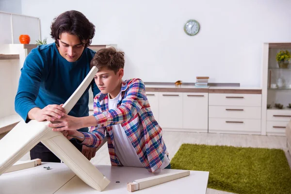 Jovem carpinteiro ensinando seu filho — Fotografia de Stock