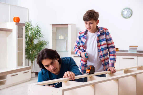 Jonge timmerman die zijn zoon onderwijst — Stockfoto