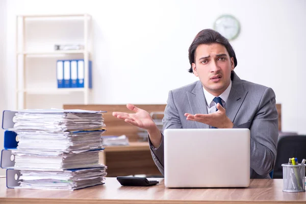 Joven empleado masculino infeliz con el trabajo excesivo — Foto de Stock