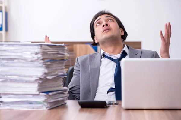 Joven empleado masculino infeliz con el trabajo excesivo — Foto de Stock