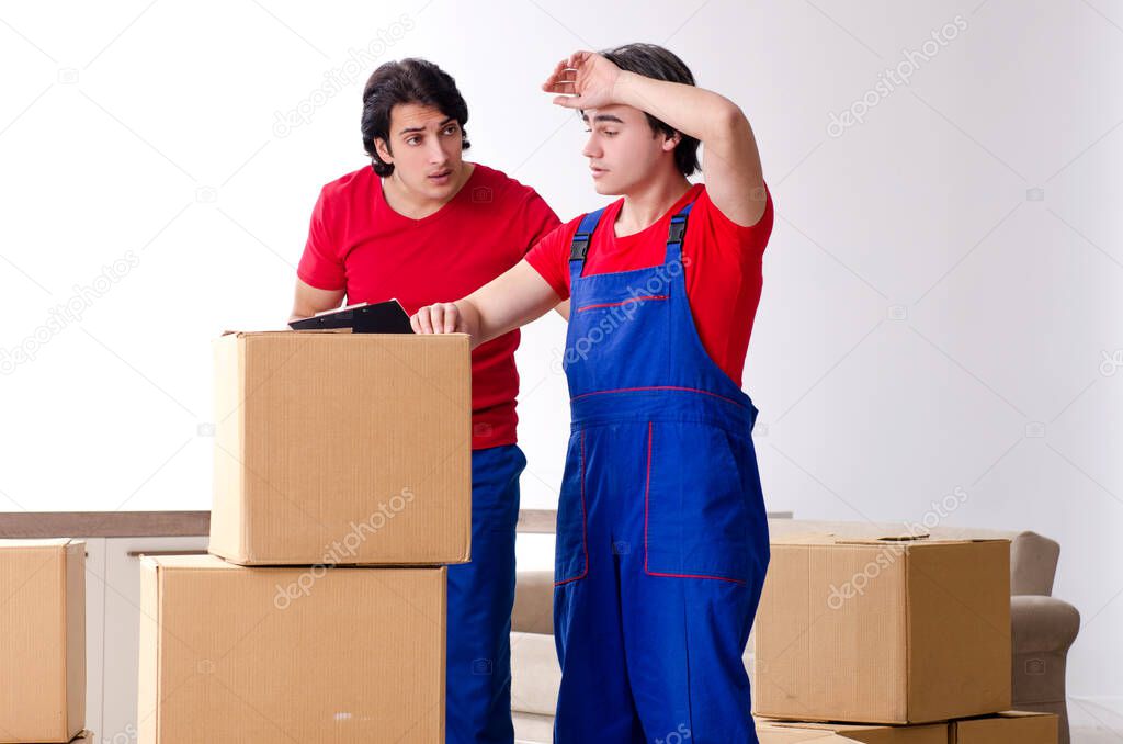 Two young contractor employees moving personal belongings