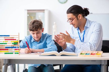 Genç baba oğlunun sınava hazırlanmasına yardım ediyor.