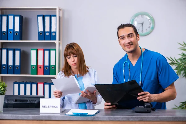 Dva lékaři pracující na recepci v nemocnici — Stock fotografie