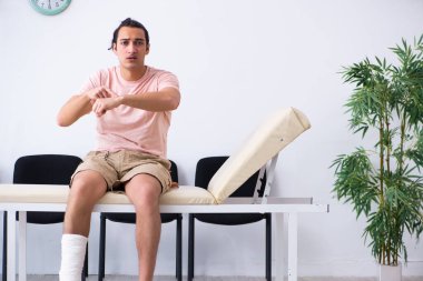 Genç yaralı adam hastane koridorunda sırasını bekliyor.