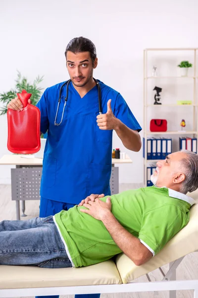 Oude man op bezoek bij jonge mannelijke arts gastro-enteroloog — Stockfoto