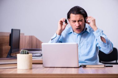 Masasında çalışan çağrı merkezi operatörü.