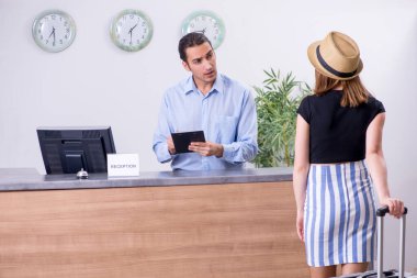 Otel resepsiyonundaki genç kadın.