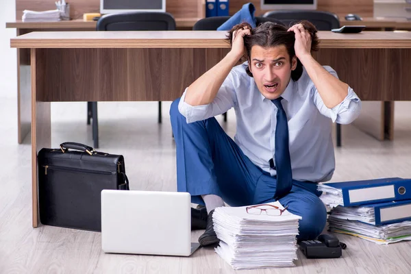 Jeune employé masculin et trop de travail au bureau — Photo