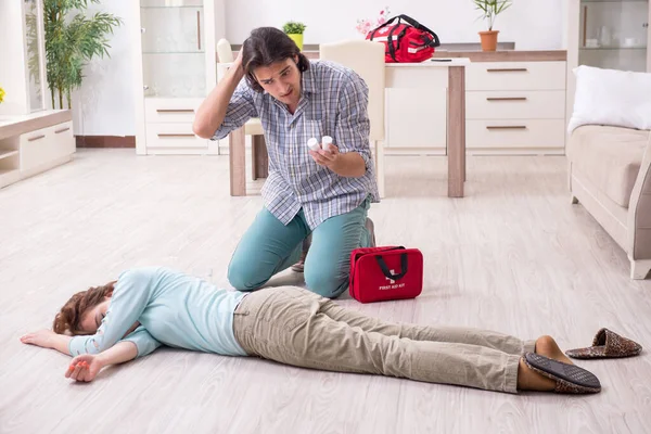 Pareja joven en concepto de primeros auxilios en casa — Foto de Stock