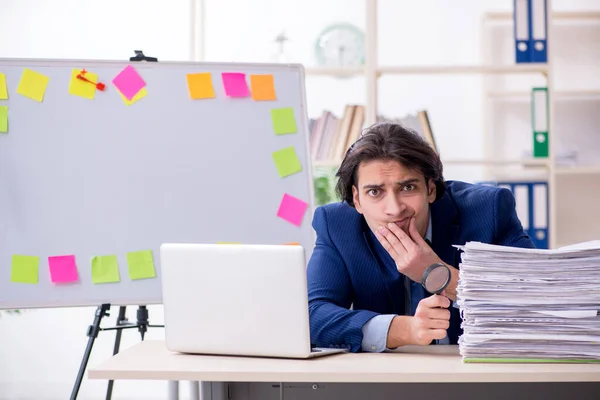 Joven empleado masculino infeliz con el trabajo excesivo — Foto de Stock