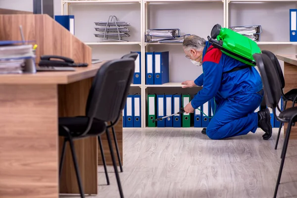 Stary profesjonalny wykonawca zajmujący się zwalczaniem szkodników w biurze — Zdjęcie stockowe