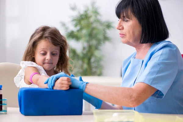 Bambina in visita vecchio medico femminile — Foto Stock