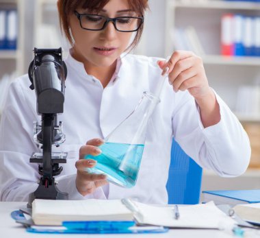 Bir laboratuarda deney yapan kadın bir bilim adamı.