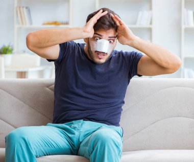 Genç adam estetik cerrahi burnundan sonra evde iyileşiyor.