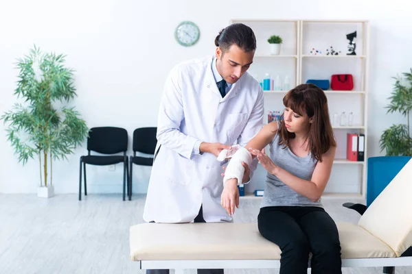 Jonge vrouw op bezoek bij mannelijke arts traumatoloog — Stockfoto