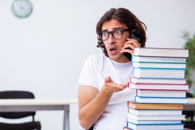 Sınıfta oturan genç erkek öğrenci.