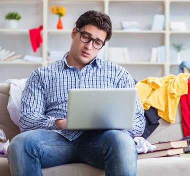 Genç adam dağınık bir odada çalışıyor.