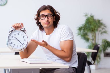 Sınıfta oturan genç erkek öğrenci.