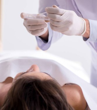 Adli tabip morgdaki cesedi inceliyor.