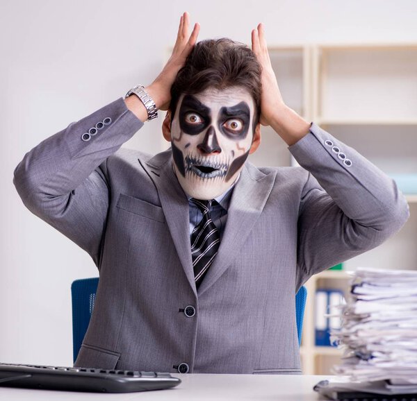 Бизнесмены в страшной маске работают в офисе