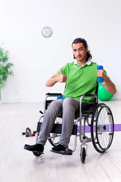 Joven en silla de ruedas haciendo ejercicios en interiores —  Fotos de Stock