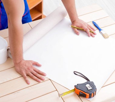 Tadilat sırasında duvar kâğıdı üzerinde çalışan işçiler