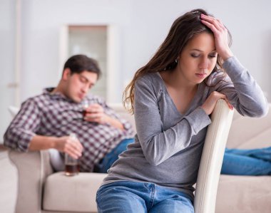 Genç bir aile kavramında içki sorunu yaşayan sarhoş bir koca.