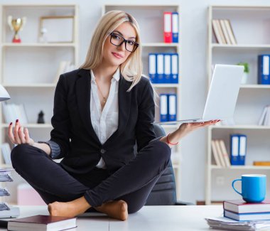 İş kadını ofiste meditasyon yaparken hayal kırıklığına uğradı