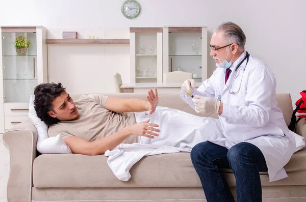 Stary lekarz odwiedził młodego pacjenta płci męskiej — Zdjęcie stockowe