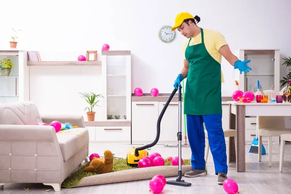 Jovem empreiteiro do sexo masculino fazendo trabalhos domésticos após a festa — Fotografia de Stock