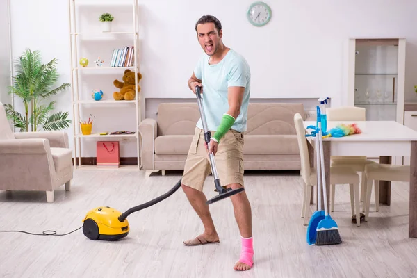 Jonge gewonde man die het huis schoonmaakt — Stockfoto