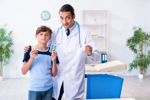 Молодой врач осматривает мальчика в клинике — стоковое фото