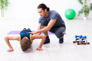 Genç baba ve oğlu egzersiz yapıyor.