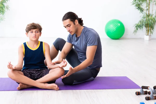 Jovem pai e seu filho fazendo exercícios — Fotografia de Stock