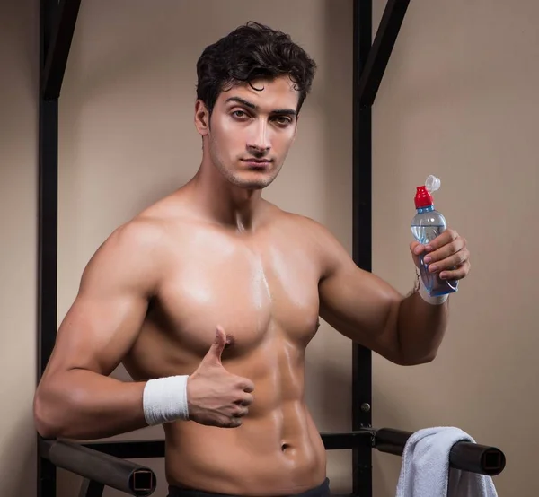 Hombre sediento bebiendo agua en el gimnasio deportivo — Foto de Stock