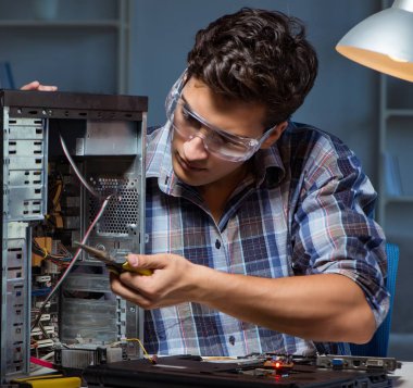 Bilgisayar masaüstünü penseyle tamir eden adam